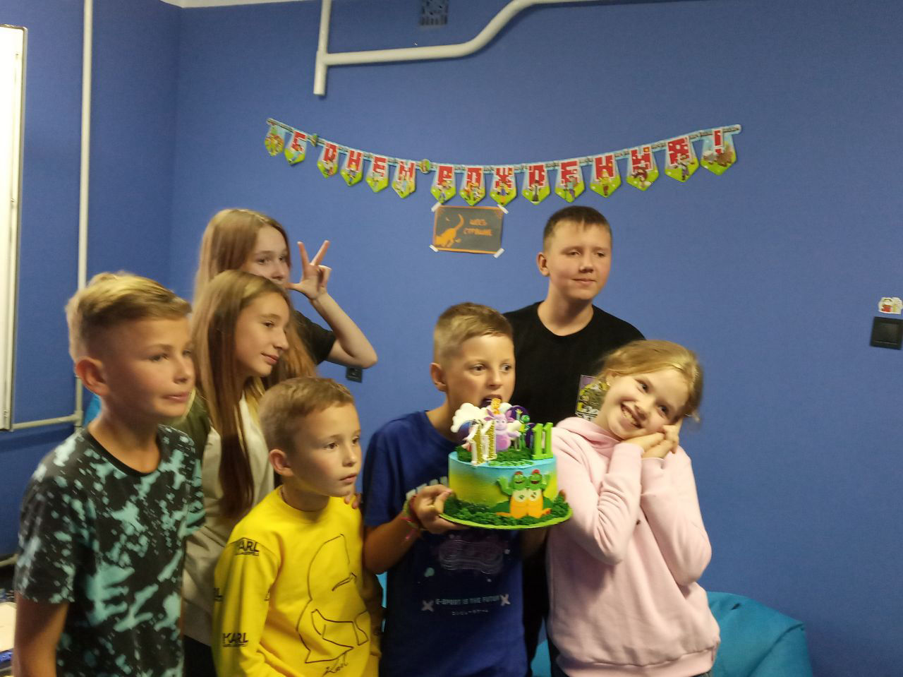 Іменинник задуває свічки на торті. Він святкує свій день народження в нашому клубі. Вересень 2023 року, Харків. Клуб віртуальної реальності.
